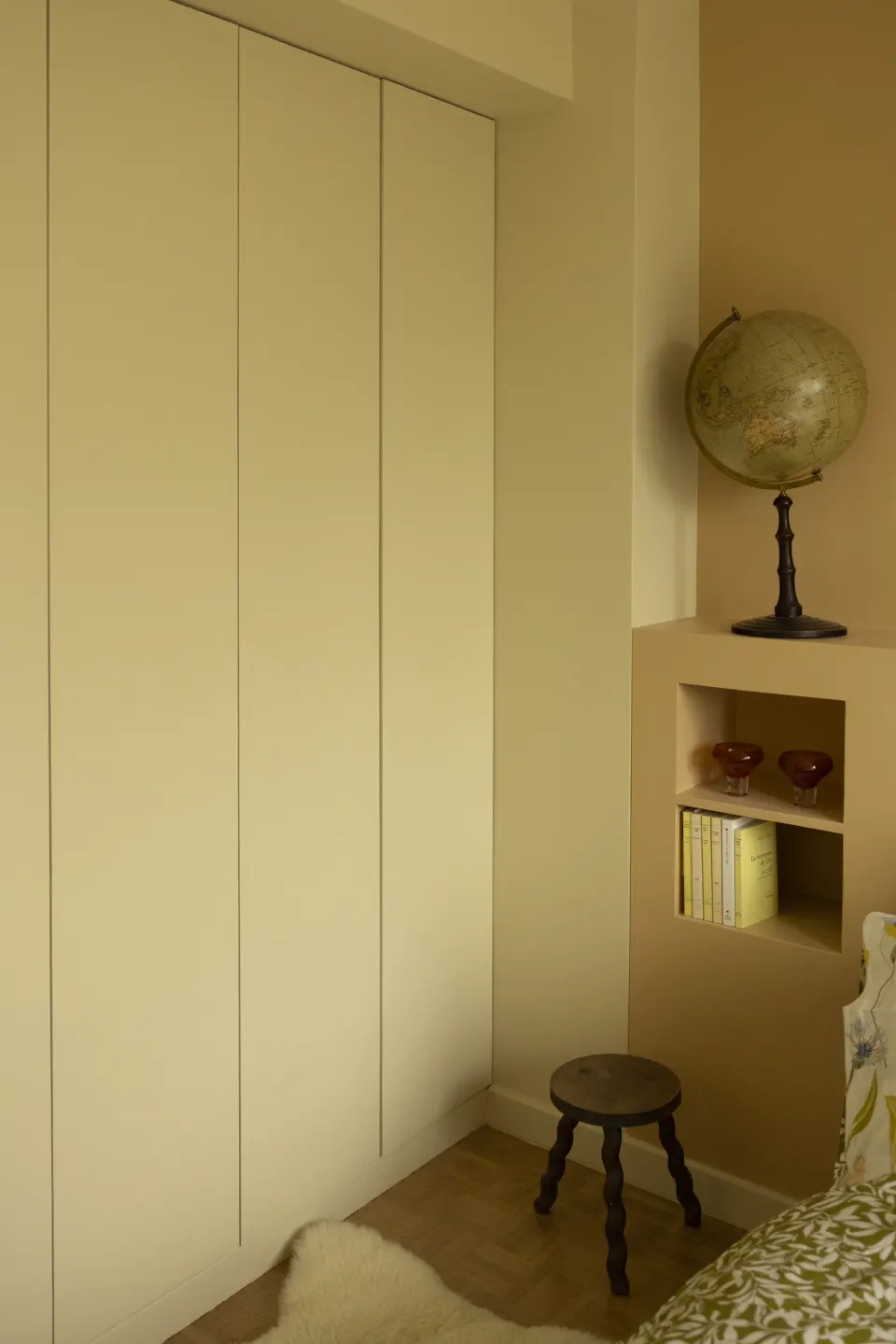 Built-in cream wardrobe, globe and dark stool