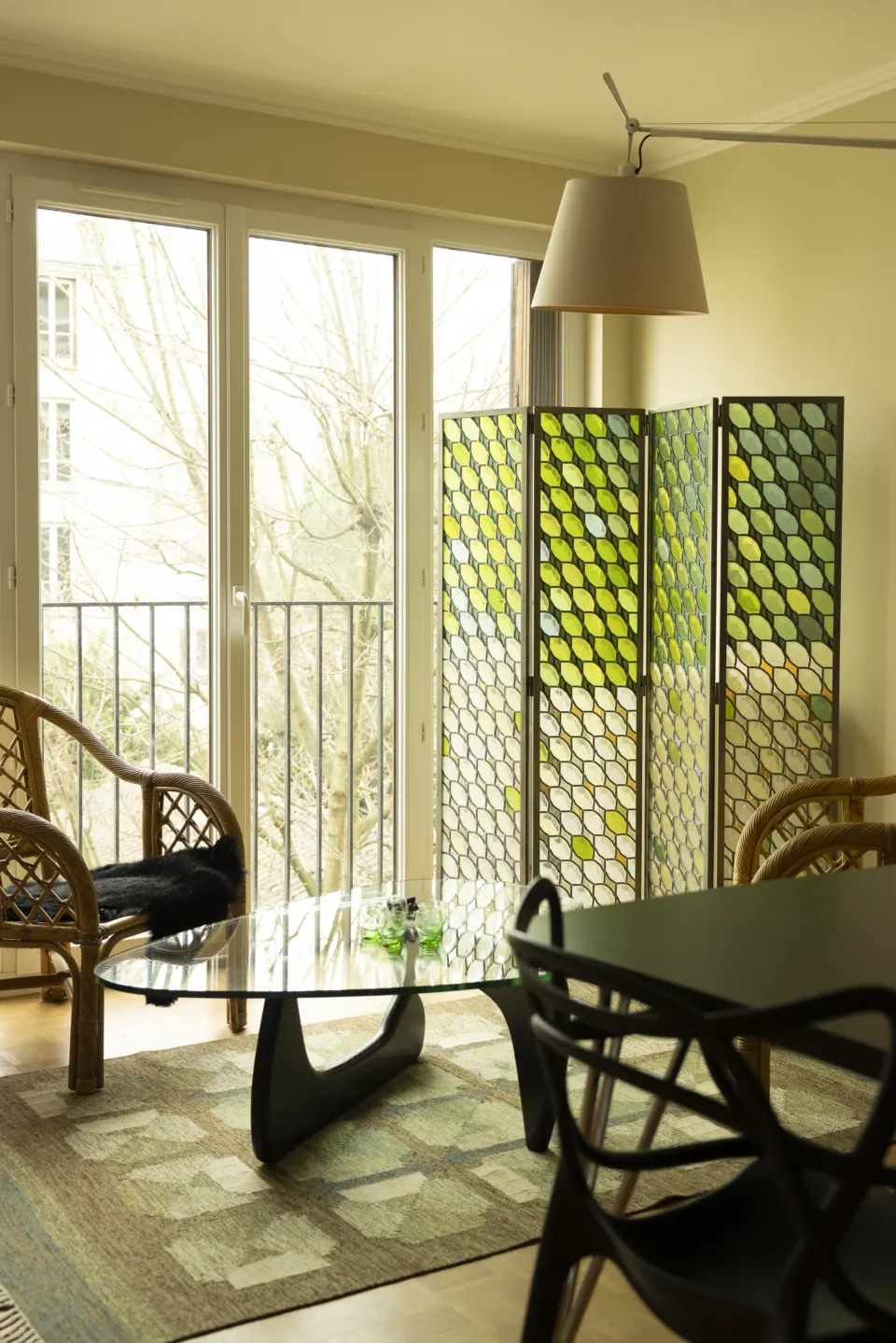 Living room with green screen, rattan armchairs and glass coffee table