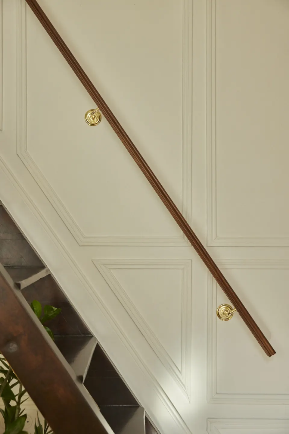 Cream panelling, dark wood handrail and brass fittings