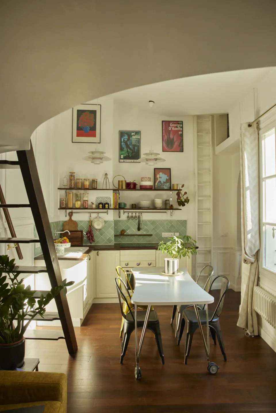 Dining corner seen through an arch, cream walls, parquet and plants