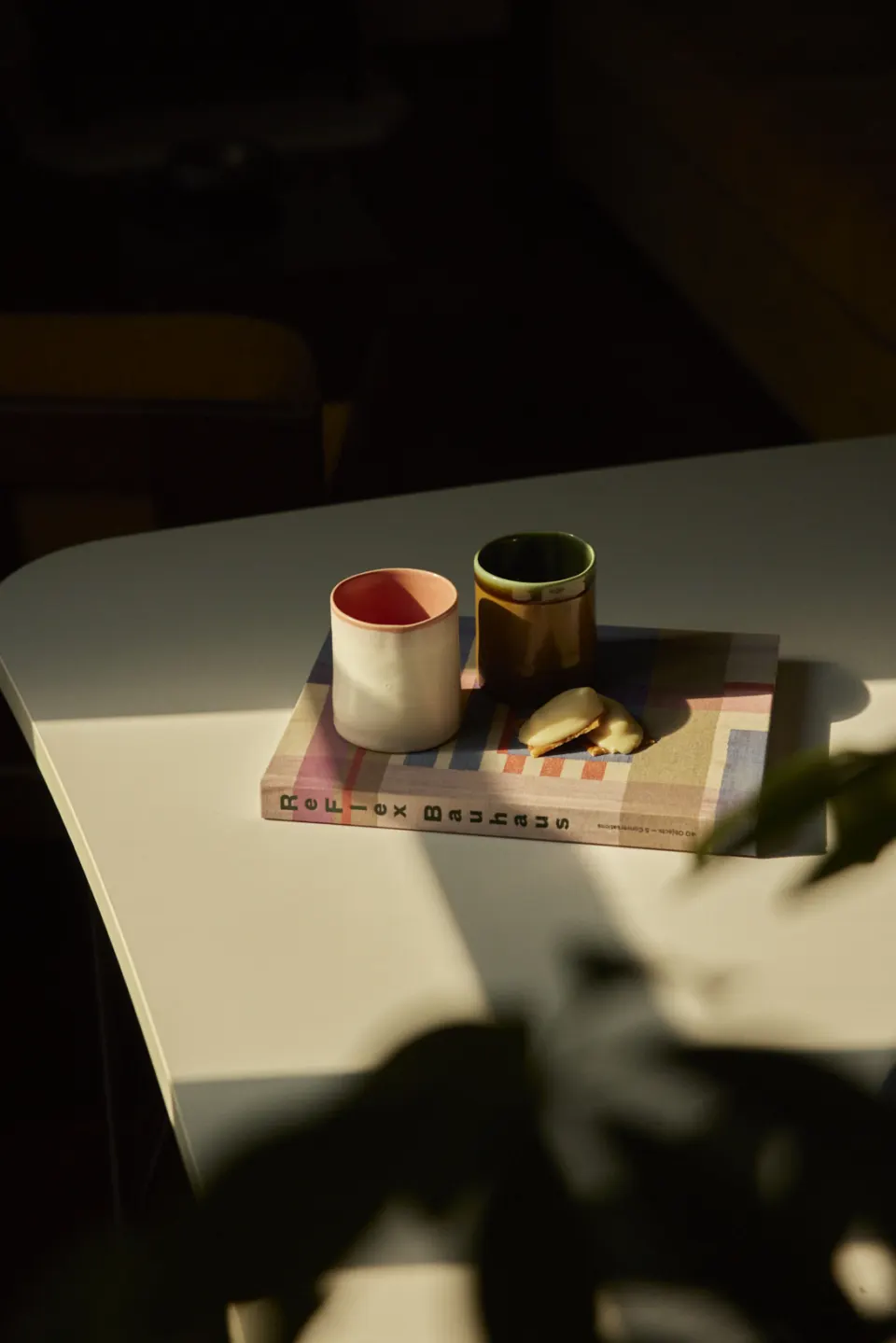 Two cups on a book, raking light