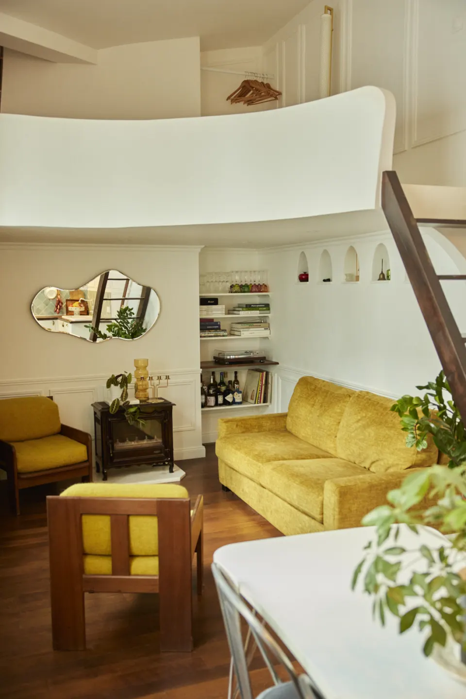 Living room seen from above, mustard sofa and white mezzanine with soft curves